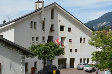 The parish hall does not copy the Engadine house, but reinterprets it.