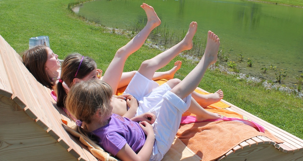 formschöne Holzliegen am See