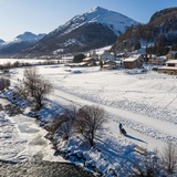 View of Madulain, in the foreground the winter hiking trail parallel to the ice path