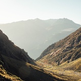 Ein Tal von der Sonne in warmes Licht gebettet.