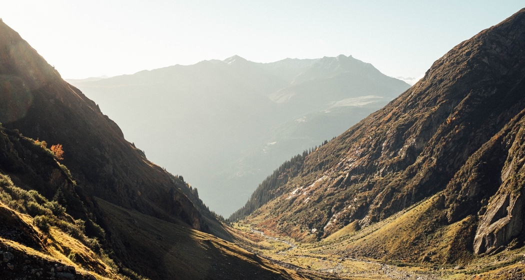 Ein Tal von der Sonne in warmes Licht gebettet.