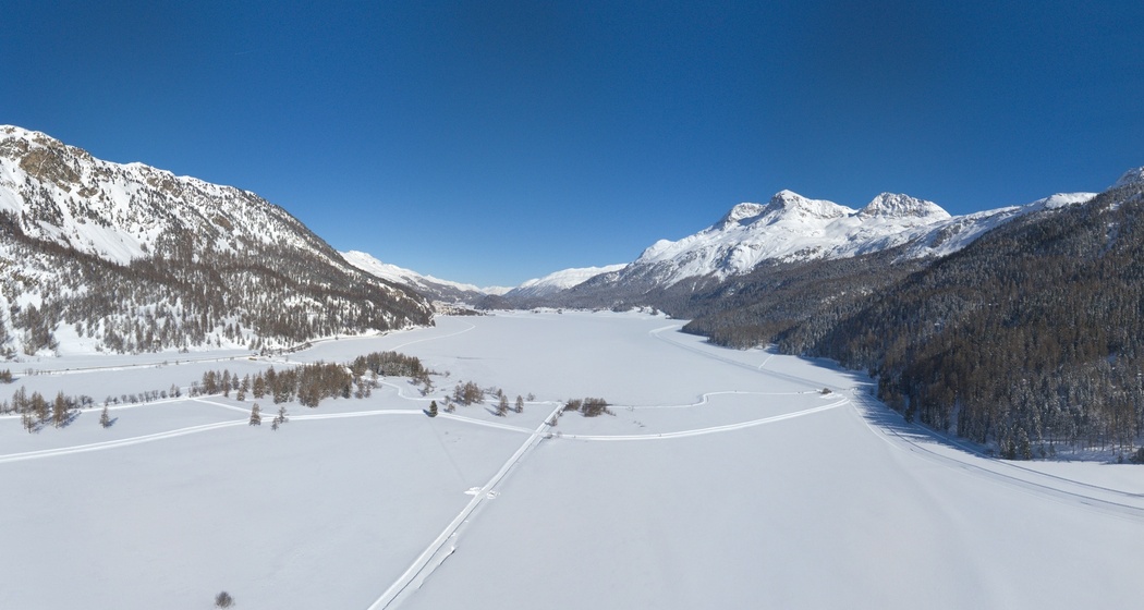 Blick von Oben auf einen Teil der Rundloipe und den gefrorenen Silvaplanasee