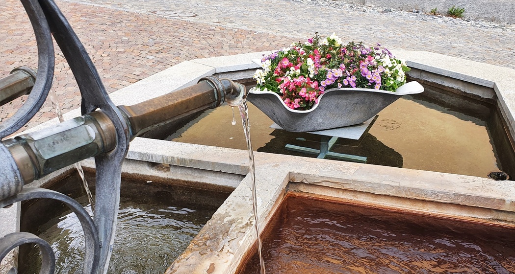 Mineralwasser der Sotsass-Quelle am Dorfbrunnen Bagnera