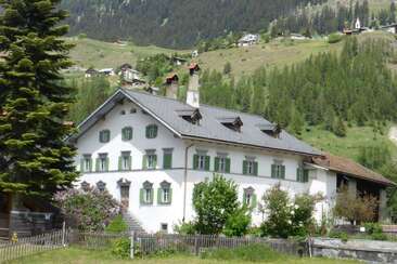 Haus Buol Bergün Sommer, im Hintergrund das schöne Bergdorf Latsch
