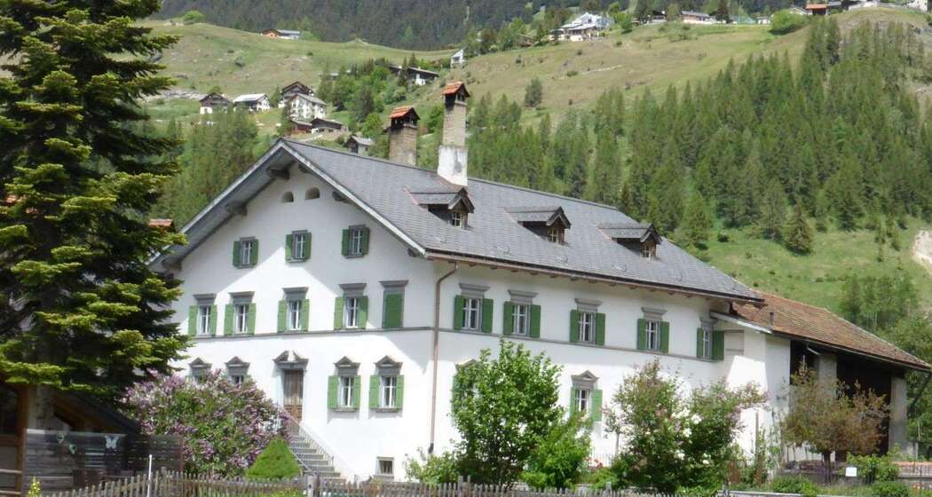Haus Buol Bergün Sommer, im Hintergrund das schöne Bergdorf Latsch