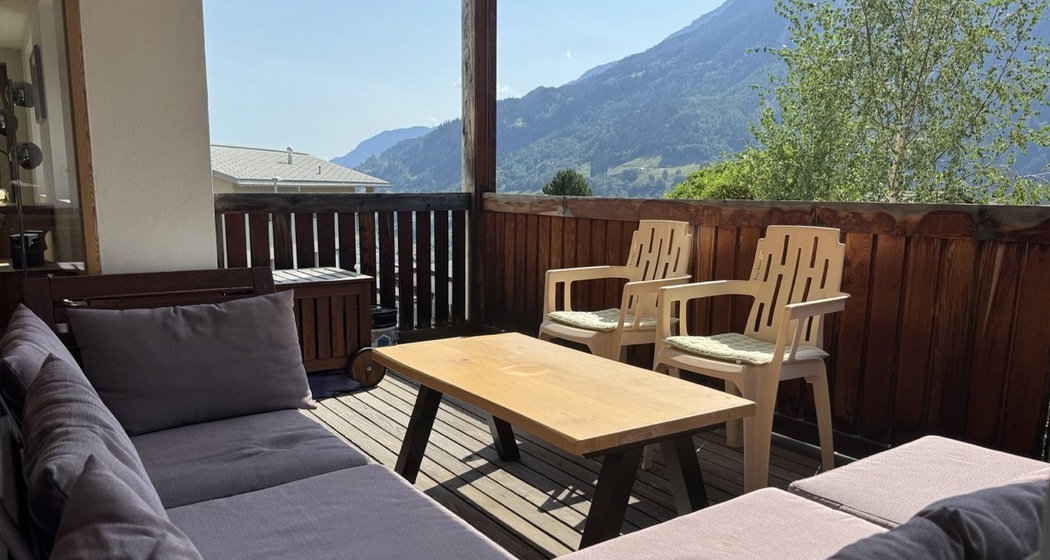 South-facing covered 11.5 m² terrace with comfortable outdoor sofa seating, dining table and chairs