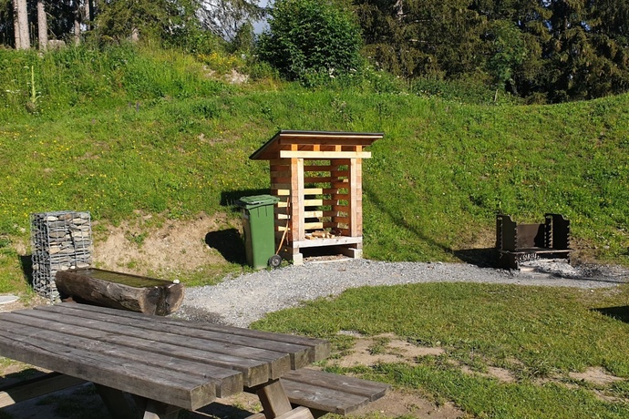 The photo shows the fireplace next to the tennis court in Brigels