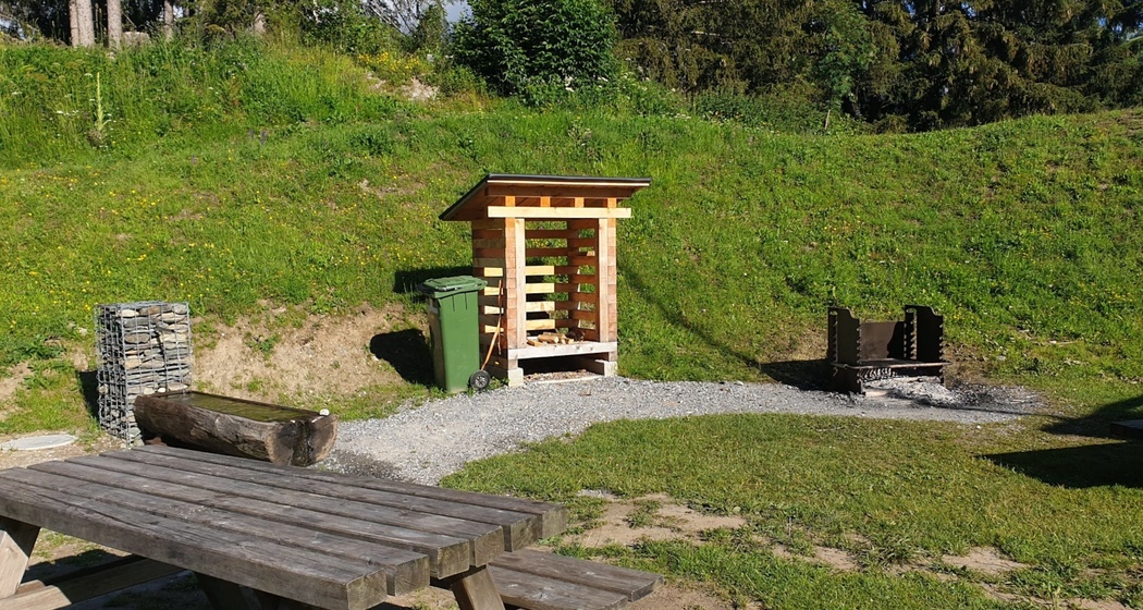 Das Foto zeigt die Feuerstelle neben dem Tennisplatz in Brigels
