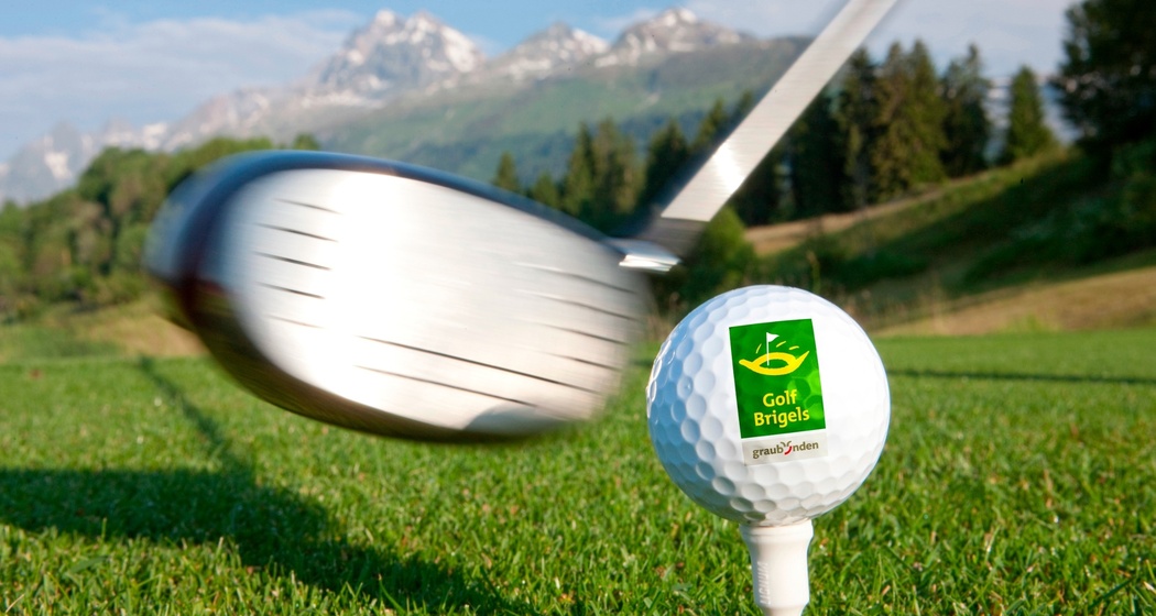 Das Foto zeigt einen Golfschläger der kurz davor steht einen Golfball zu schießen