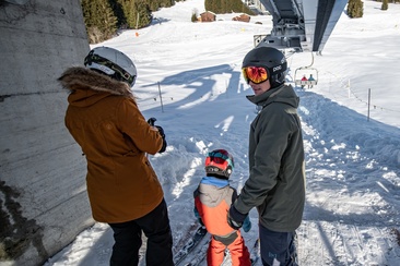 Das Foto zeigt eine Familie die in der Mittelstation im Winter einsteigen
