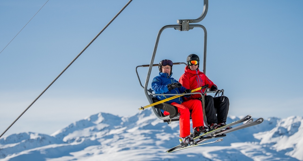 Das Foto zeigt zwei Männer auf der Sesselbahn