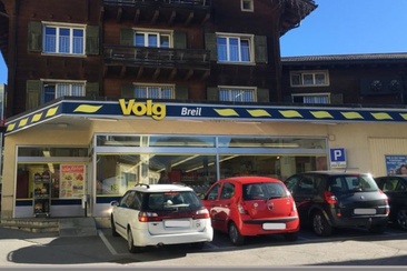 Das Foto zeigt den Eingang und Parkplatz des Volgs in Brigels