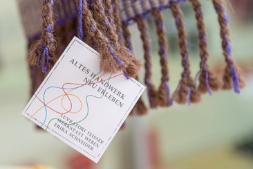 Das Foto zeigt das Logo der Werkstatt Weben in Brigels