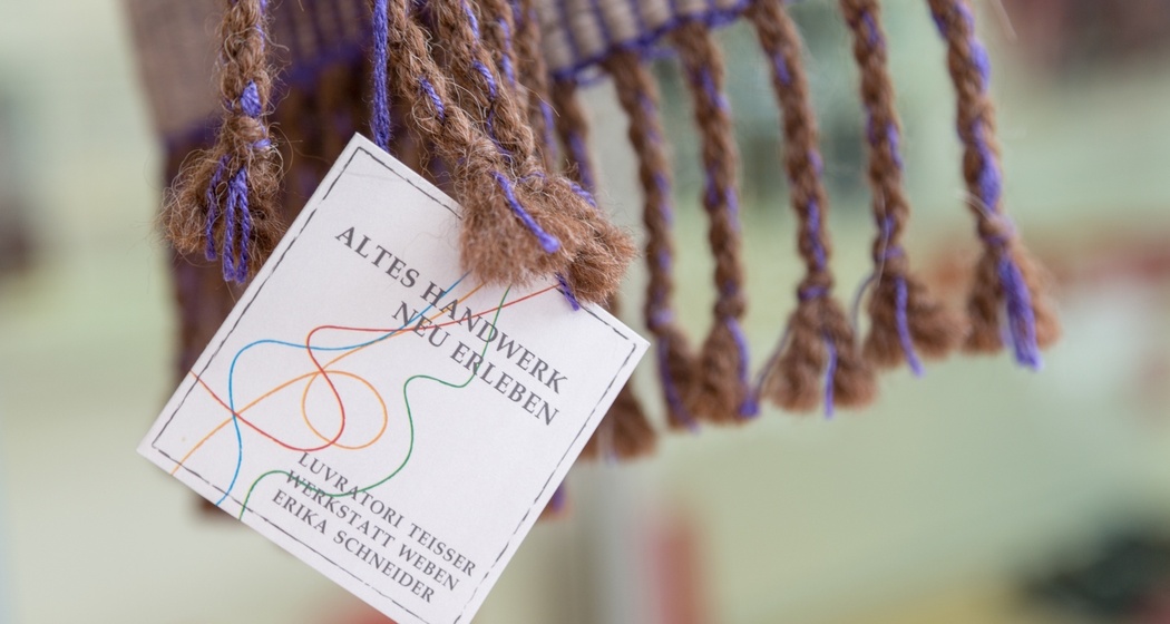 Das Foto zeigt das Logo der Werkstatt Weben in Brigels