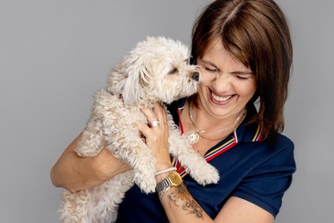 Nahaufnahme von Frau Killias mit einem Hund im Arm.