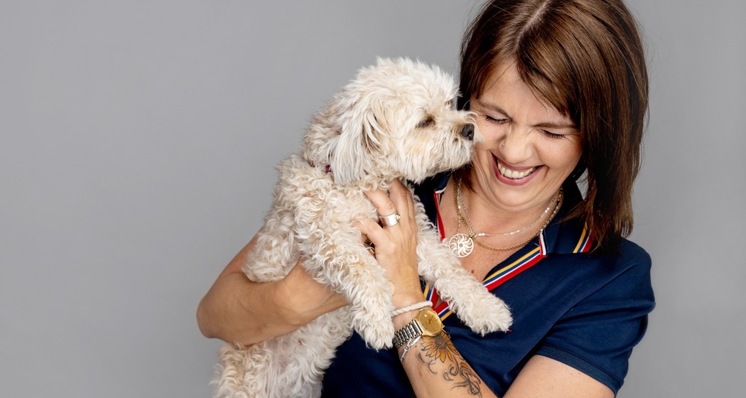 Nahaufnahme von Frau Killias mit einem Hund im Arm.