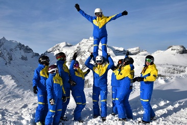 Das Foto zeigt Skilehrer die auf der Piste ohne Ski Spaß haben
