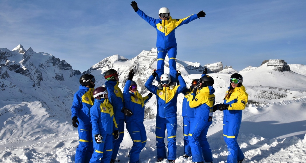 Das Foto zeigt Skilehrer die auf der Piste ohne Ski Spaß haben