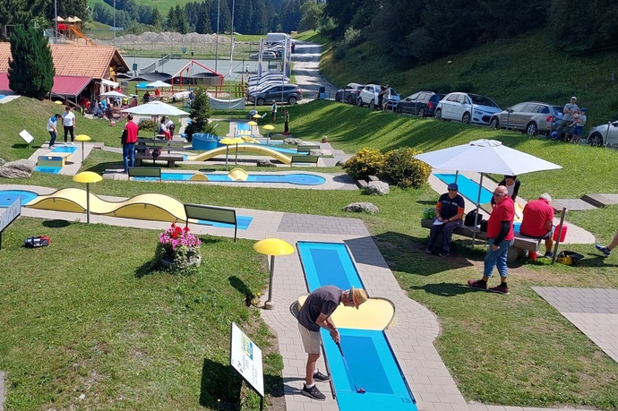 Das Foto zeigt die Minigolfanlage mit vielen Besuchern.