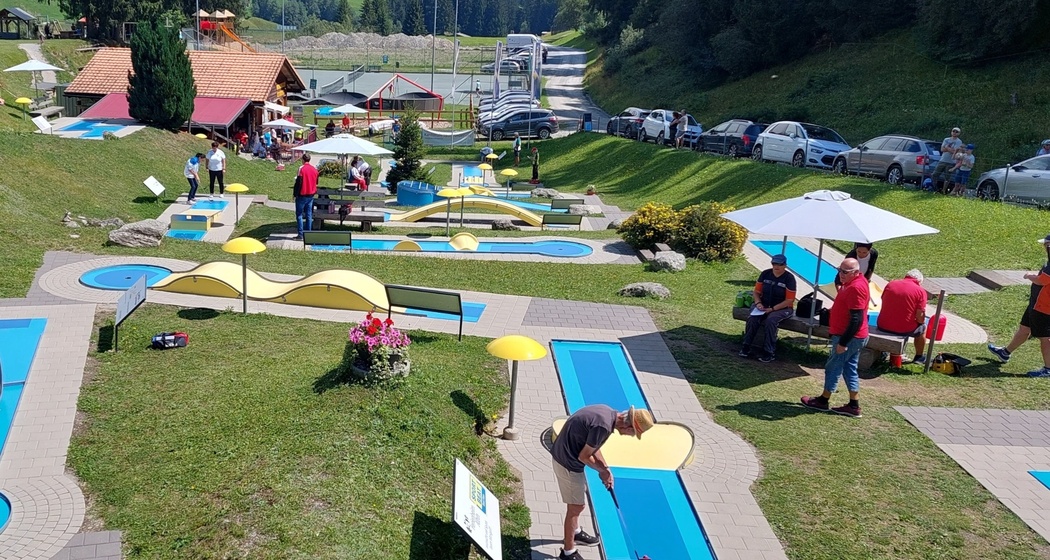 Das Foto zeigt die Minigolfanlage mit vielen Besuchern.