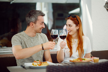 Paar stösst mir Rotwein an, Hauptgang im Restaurant Chrüz