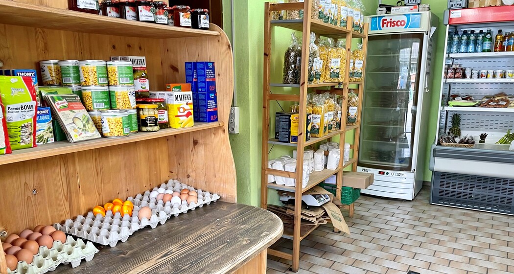 Innenansicht des Hofladens Aeulehof mit Regal voller regionaler Produkte, darunter Eier und Konserven.
