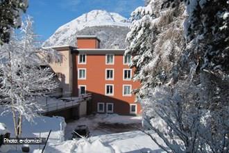 Vista casa in inverno con parcheggio e garage