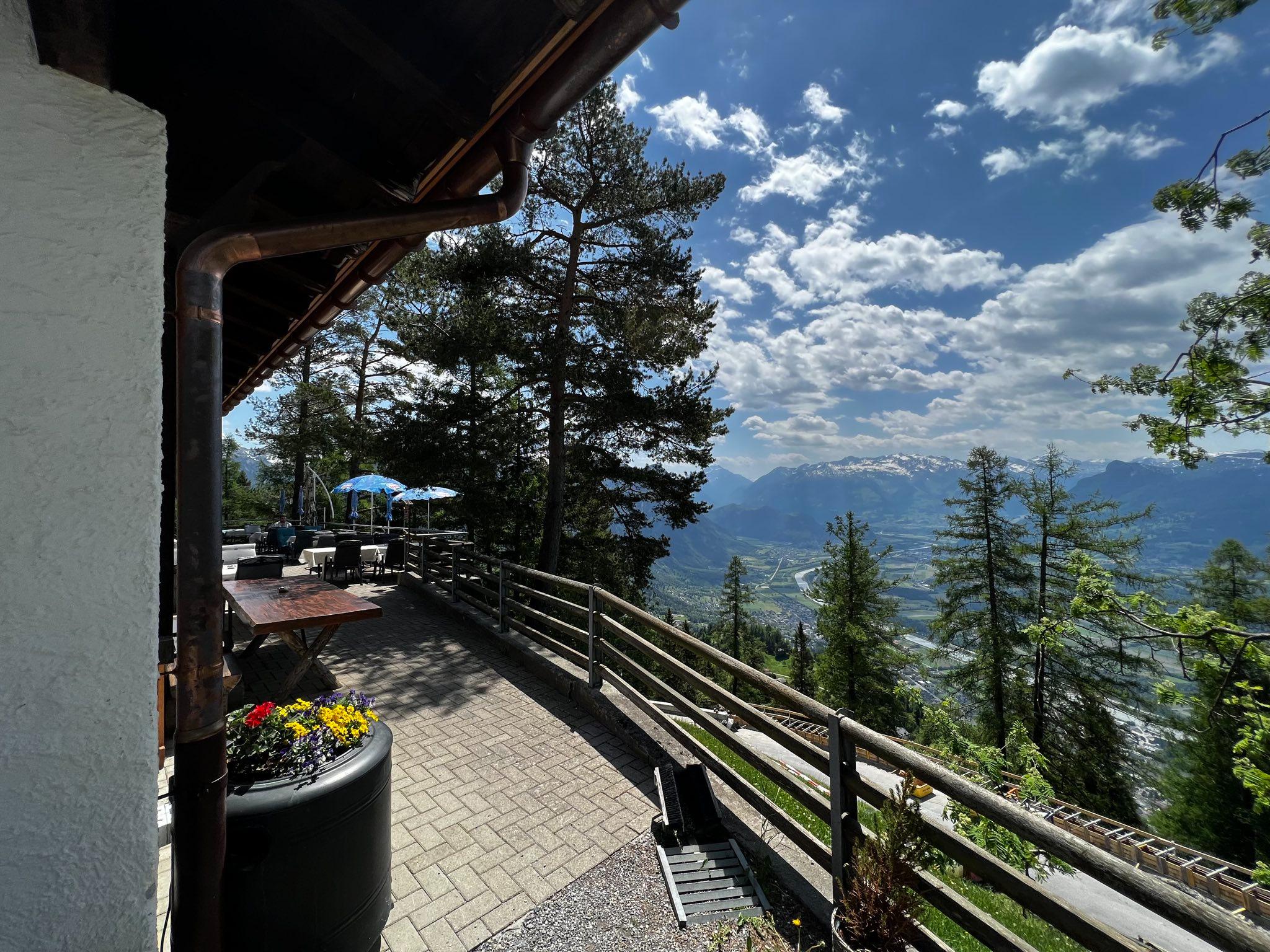 Sonnenterrasse des Berggasthauses Matu mit Blick auf das Rheintal und die umliegende Berglandschaft.